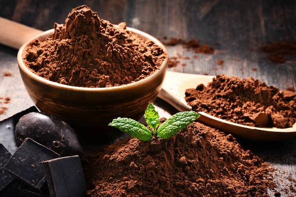 Composition with bowl of cocoa powder on wooden table — Stock Photo, Image