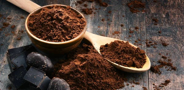 Samenstelling met kom cacaopoeder op houten tafel — Stockfoto