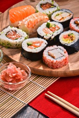 Kompozisyon ile çeşitli suşi rulo ve baharatlar kase