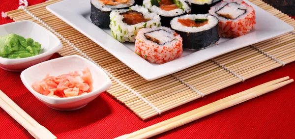 Kompozycja z różne sushi rolki i miski przypraw — Zdjęcie stockowe