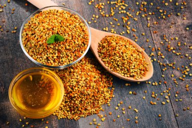 Bowls with bee pollen and honey on kitchen table