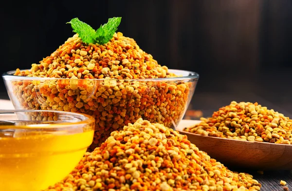 Чаши с пчелиной пыльцой и медом на кухонном столе — стоковое фото