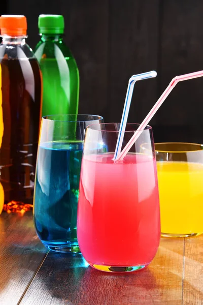 各种颜色的各式碳酸软饮料的玻璃和瓶子 — 图库照片
