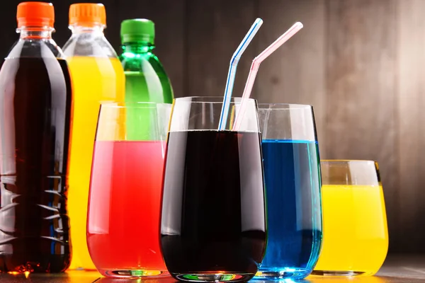 各种颜色的各式碳酸软饮料的玻璃和瓶子 — 图库照片