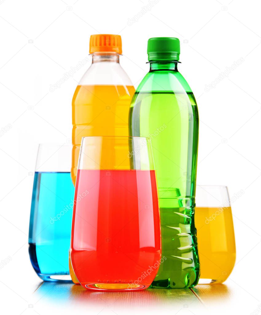 Glasses and bottles of assorted carbonated soft drinks isolated on white