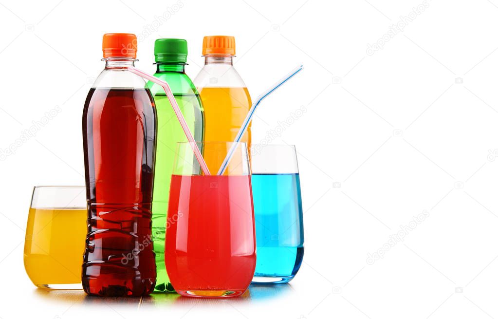 Glasses and bottles of assorted carbonated soft drinks isolated on white