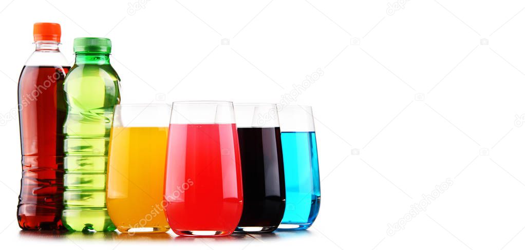 Glasses and bottles of assorted carbonated soft drinks isolated on white