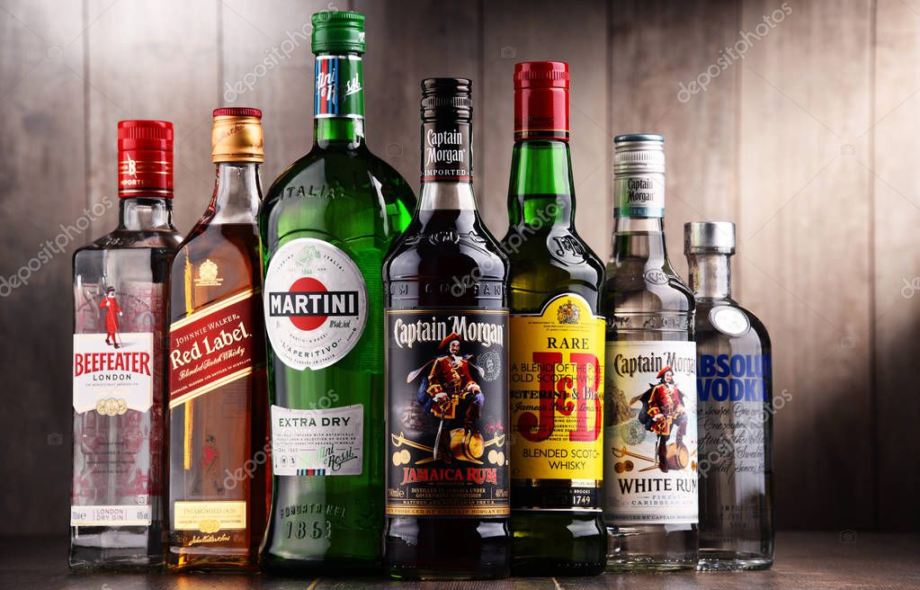 POZNAN, POLAND - DEC 15, 2017: Bottles of assorted global liquor brands including Martini, Johnnie Walker, Captain Morgan, Absolut Vodka, Beefeater and JB