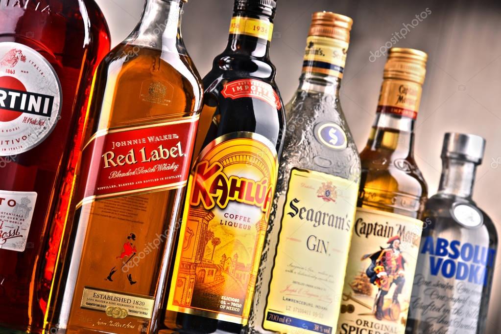 POZNAN, POLAND - DEC 15, 2017: Bottles of assorted global liquor brands including Martini, Johnnie Walker, Captain Morgan, Absolut Vodka, Seagram and Kahlua
