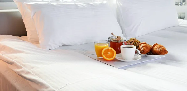 Frukost på sängen i hotellrum. — Stockfoto