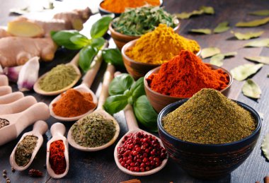 Mutfak masasında çeşitli baharat ve bitkiler var.