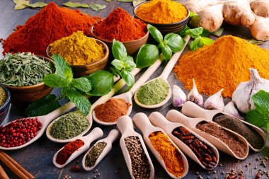 Mutfak masasında çeşitli baharat ve bitkiler var.