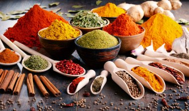Mutfak masasında çeşitli baharat ve bitkiler var.