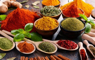 Mutfak masasında çeşitli baharat ve bitkiler var.