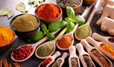 Mutfak masasında çeşitli baharat ve bitkiler var.