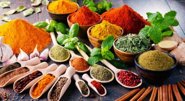 Mutfak masasında çeşitli baharat ve bitkiler var.