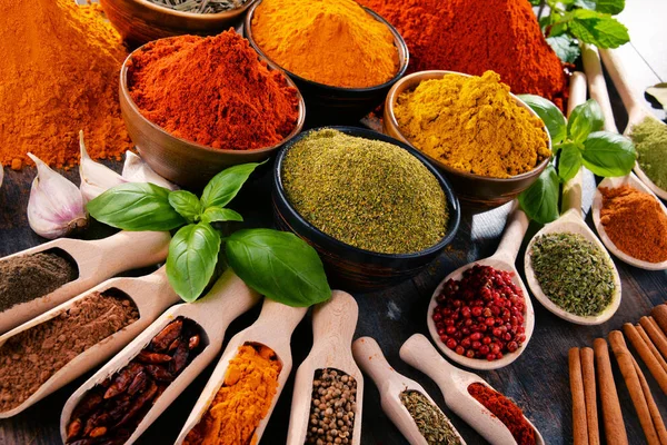 Mutfak masasında çeşitli baharat ve bitkiler var.