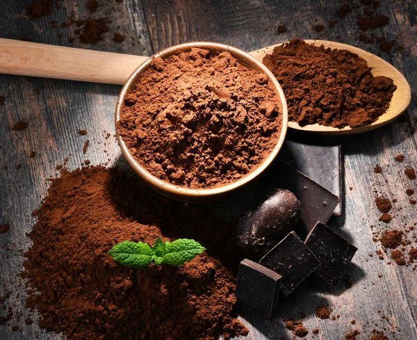 Composition with bowl of cocoa powder on wooden table — Stock Photo, Image