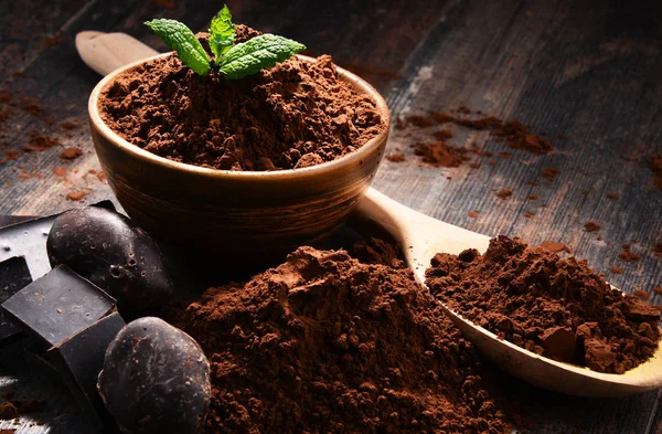 Composition with bowl of cocoa powder on wooden table — Stock Photo, Image