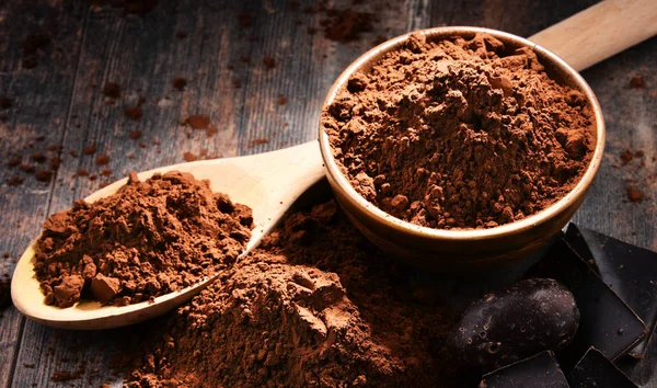 Sammansättning med skål med kakaopulver på träbord — Stockfoto