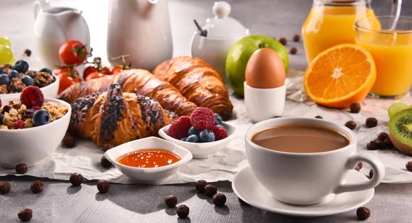 Café da manhã servido com café, suco, croissants e frutas — Fotografia de Stock