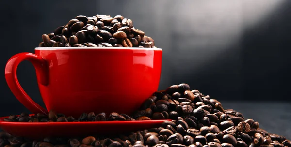 Состав с красной чашкой кофе и бобами — стоковое фото
