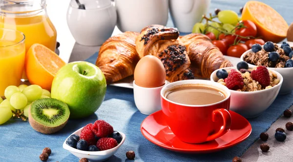 Café da manhã servido com café, suco, croissants e frutas — Fotografia de Stock