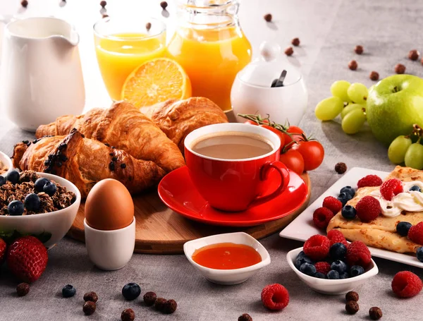 Café da manhã servido com café, suco, croissants e frutas — Fotografia de Stock