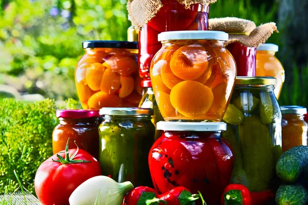 Frascos de verduras en escabeche y frutas en el jardín — Foto de Stock