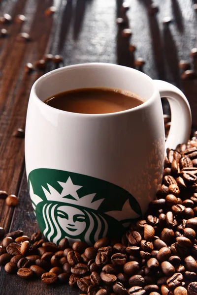 Sammansättning med kopp kaffe från Starbucks och bönor — Stockfoto