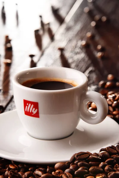 Composição com xícara de café Illy e grãos — Fotografia de Stock