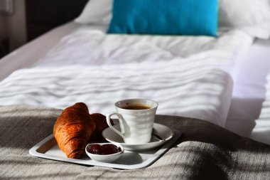Otel odasında, yatakta kahvaltı.