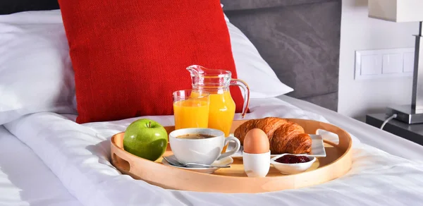 Сніданок на підносі в ліжку в готельному номері — стокове фото