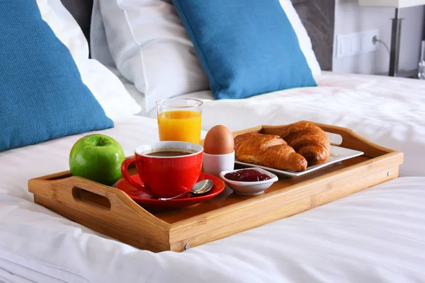 Pequeno-almoço na bandeja na cama no quarto do hotel — Fotografia de Stock