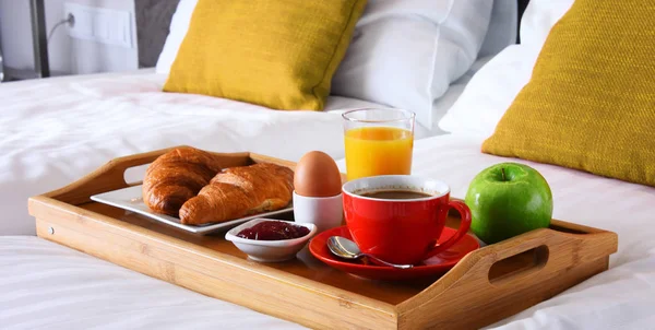 Desayuno en bandeja en la cama en la habitación del hotel —  Fotos de Stock