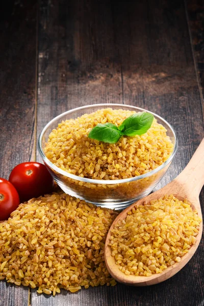 Tigela de bulgur não cozido na mesa de madeira — Fotografia de Stock