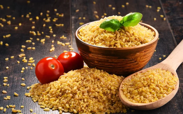 Cuenco de bulgur sin cocer sobre mesa de madera — Foto de Stock