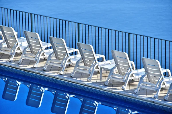 Fila de tumbonas gratuitas en la piscina de un complejo turístico — Foto de Stock