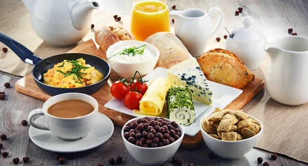 Pequeno-almoço servido com café, queijo, cereais e ovos mexidos — Fotografia de Stock