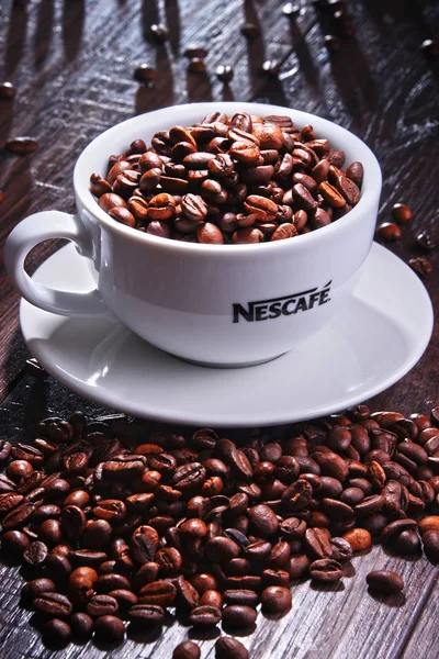 Zusammensetzung mit einer Tasse Nescafe Kaffeebohnen — Stockfoto