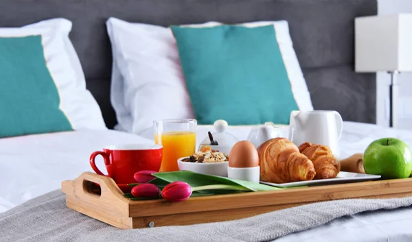 Śniadanie na tacy w łóżku w pokoju hotelowym — Zdjęcie stockowe