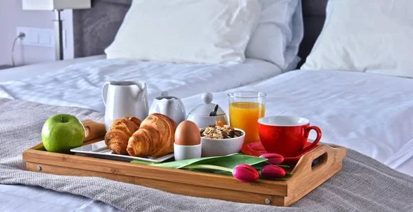 Desayuno en bandeja en la cama en la habitación del hotel —  Fotos de Stock