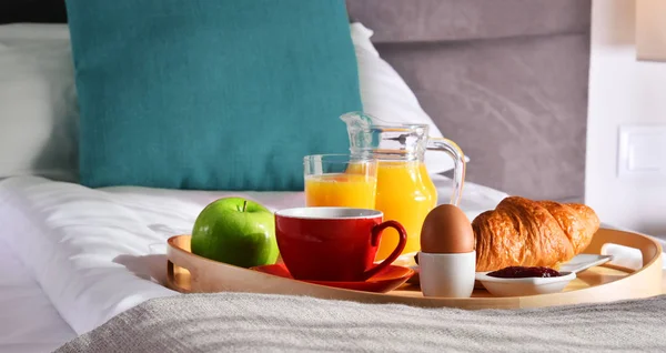 Frühstück auf Tablett im Bett im Hotelzimmer — Stockfoto