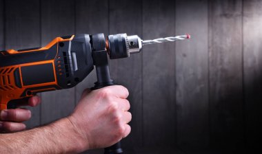 Male hands holding power drill clipart