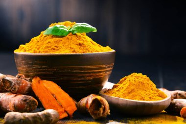 Ahşap masa üzerinde zerdeçal tozu kase ile kompozisyon