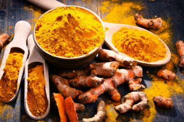 Ahşap masa üzerinde zerdeçal tozu kase ile kompozisyon