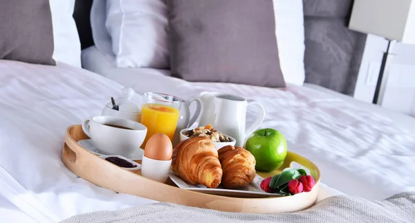 Frühstück auf Tablett im Bett im Hotelzimmer — Stockfoto