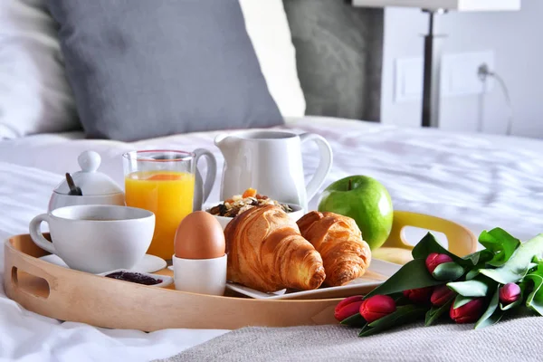 Pequeno-almoço na bandeja na cama no quarto do hotel — Fotografia de Stock