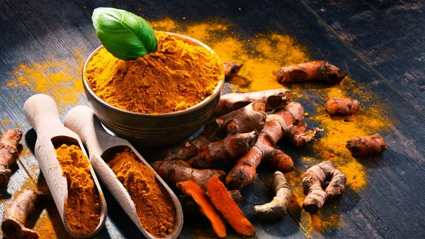 Compoziție cu castron de pulbere de turmeric pe masă de lemn — Fotografie, imagine de stoc