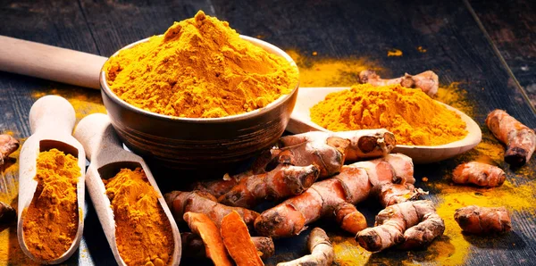 Composizione con ciotola di curcuma in polvere su tavolo di legno — Foto Stock